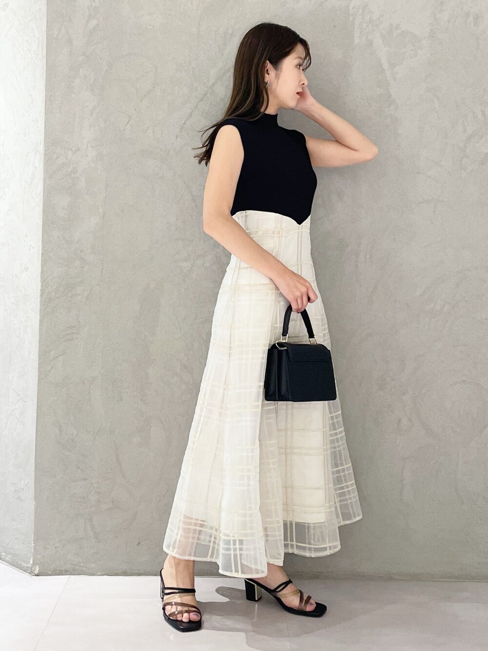 ブラック系のショルダーバッグ、ブラック系のサンダル、ブラック系のワンピースを着用したレディースの春コーディネートの3枚目の写真