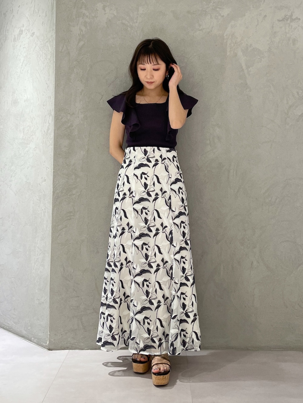 ホワイト系のスカート、グレー系のニット/セーター、ブラック系のサンダルを着用したレディースの春コーディネートの5枚目の写真