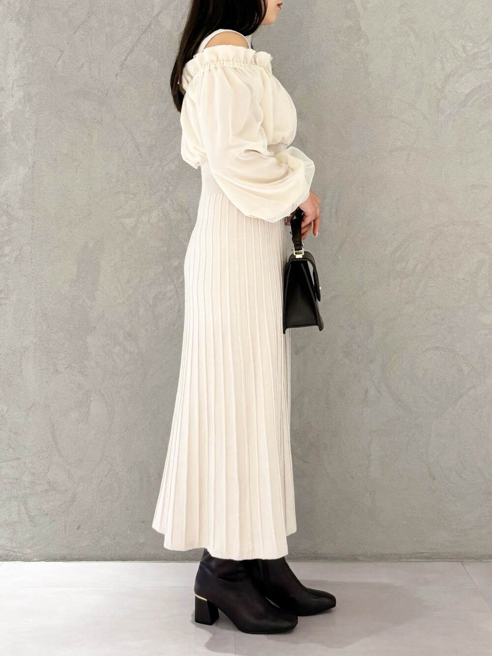 ホワイト系のワンピース、ブラウン系のブーツ、ブラウン系のハンドバッグを着用したレディースの冬コーディネートの4枚目の写真