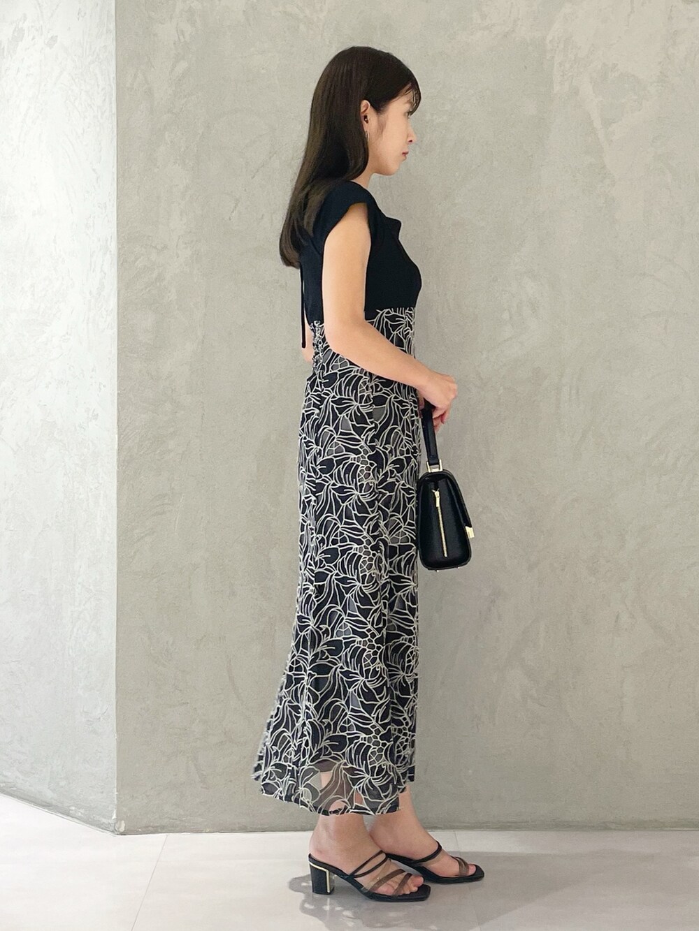 ブラック系のサンダル、ブラック系のショルダーバッグ、ブラック系のワンピースを着用したレディースの夏コーディネートの5枚目の写真