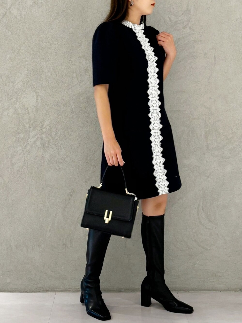 ブルー系のワンピース、ブラック系のブーツ、ブラック系のショルダーバッグを着用したレディースの秋コーディネートの4枚目の写真