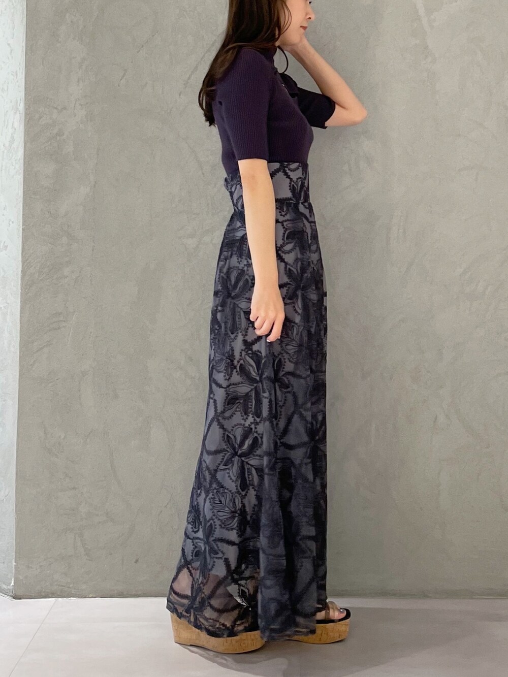 グレー系のスカート、ブラック系のサンダル、グレー系のニット/セーターを着用したレディースの春コーディネートの3枚目の写真