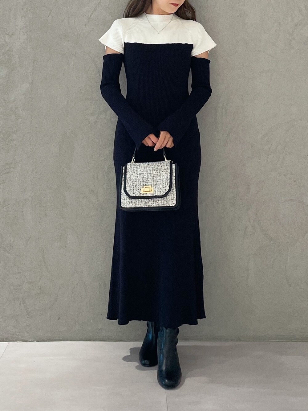 ブラック系のワンピース、ブラック系のショルダーバッグ、ブラック系のブーツを着用したレディースの秋コーディネートの4枚目の写真