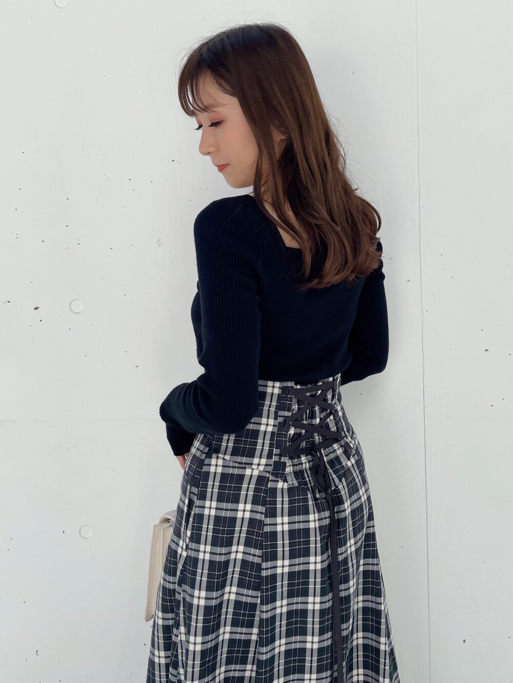 ブラック系のスカート、ブラック系のブーツ、ブラック系のニット/セーターを着用したレディースの秋コーディネートの4枚目の写真