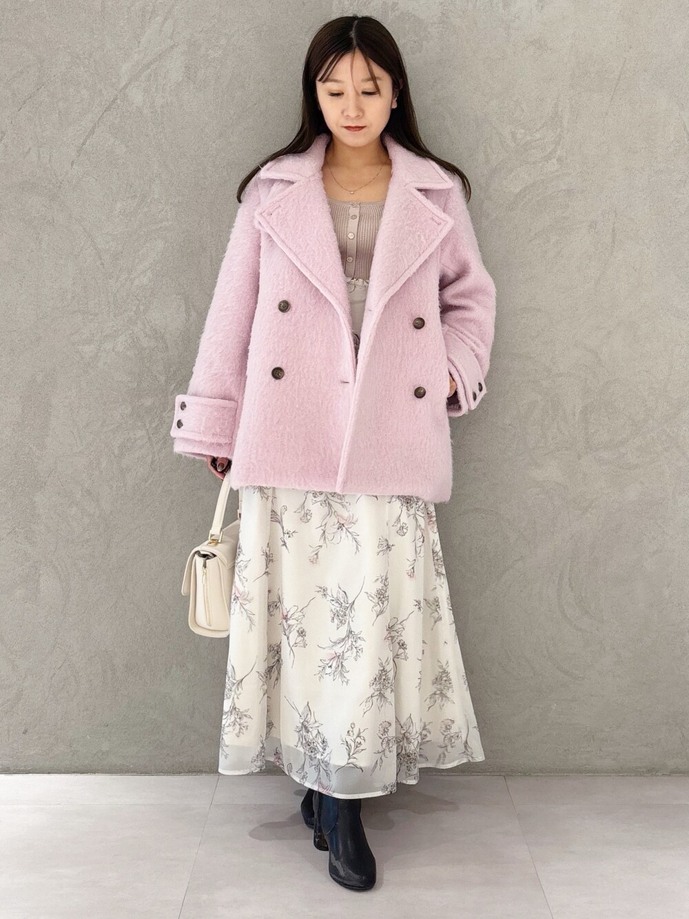 ベージュ系のワンピース、ブラック系のブーツ、ホワイト系のハンドバッグを着用したレディースの冬コーディネートの10枚目の写真