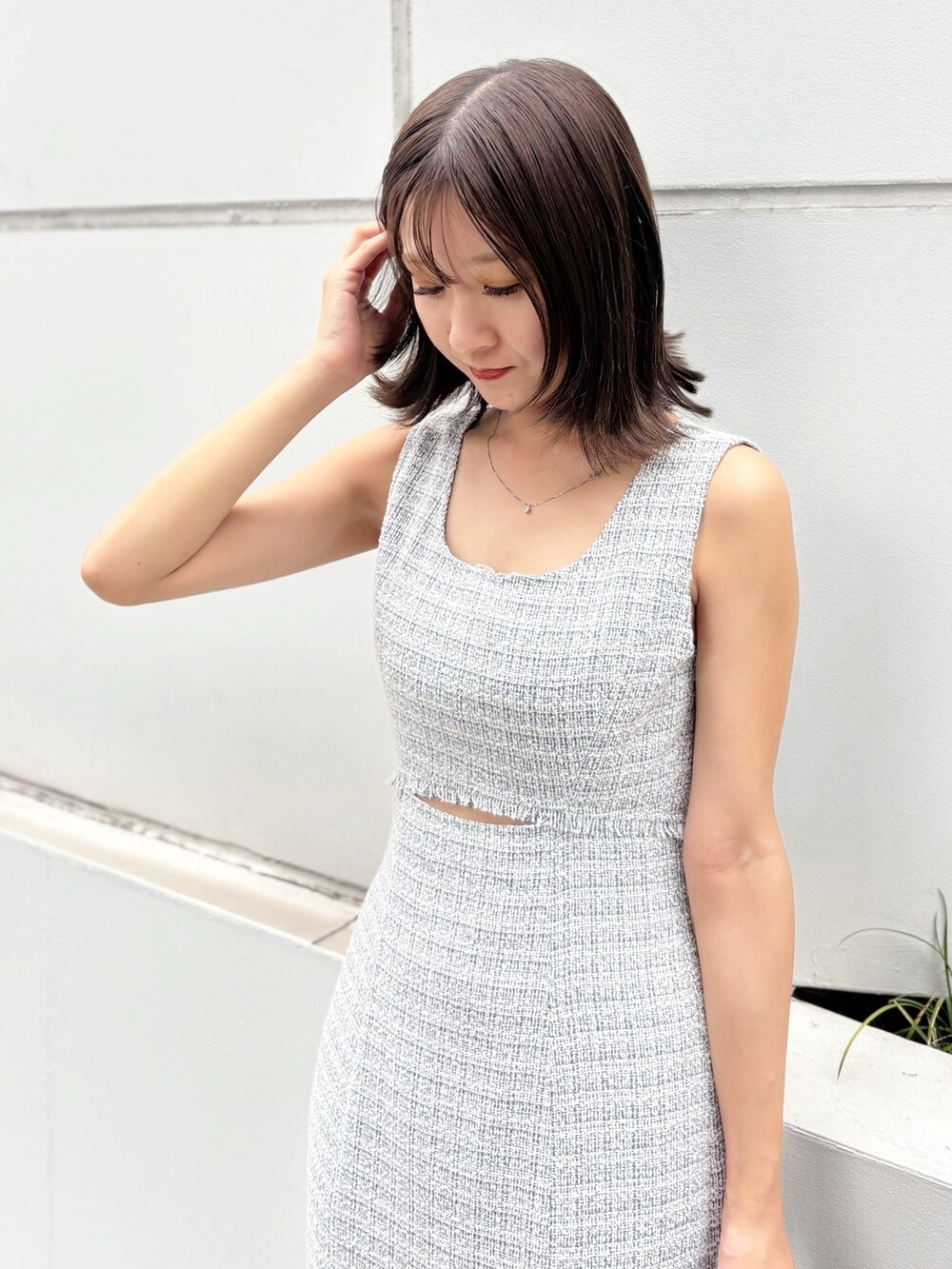 グレー系のワンピース、ホワイト系のサンダル、ブラック系のハンドバッグを着用したレディースの夏コーディネートの6枚目の写真