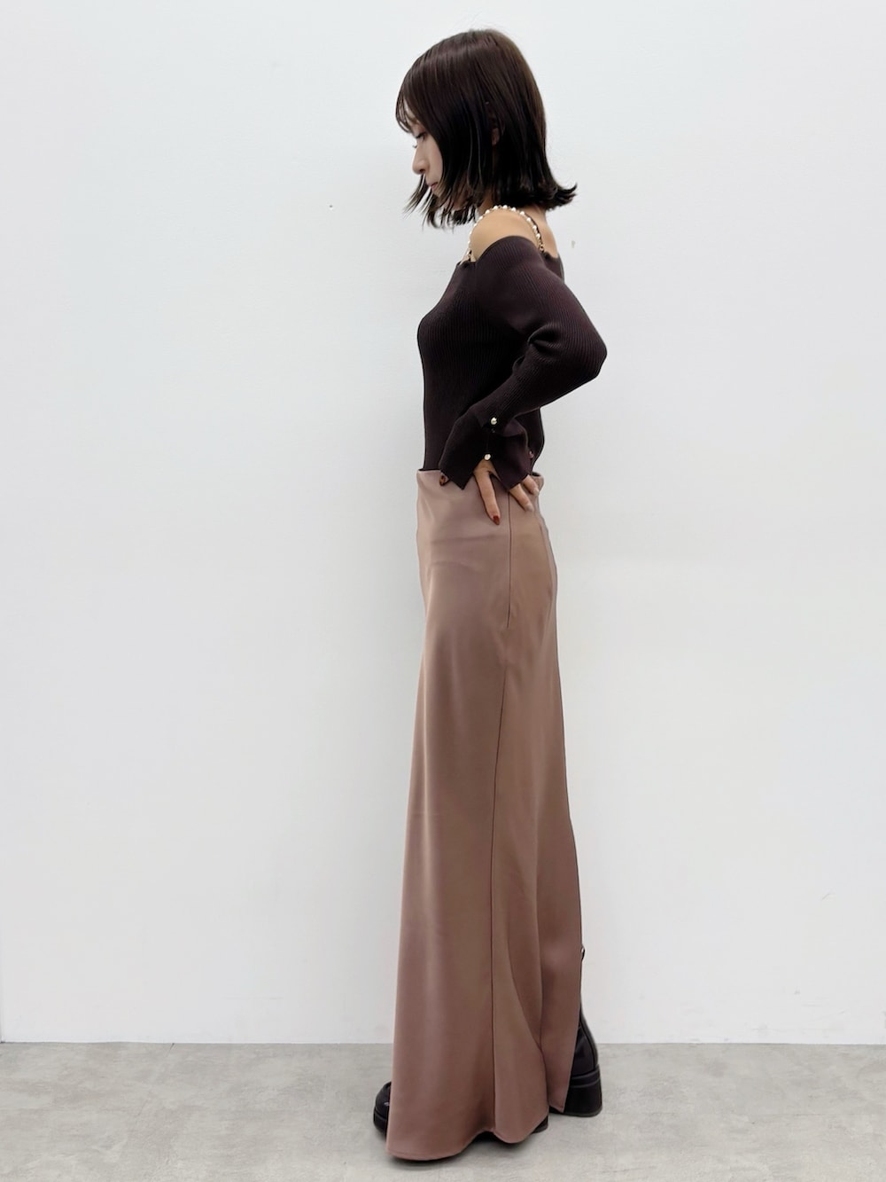 ブラウン系のスカート、ブラウン系のブーツ、ブラウン系のニット/セーターを着用したレディースの秋コーディネートの2枚目の写真