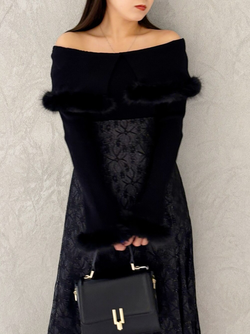 ブラック系のスカート、ブラック系のブーツ、ブラック系のショルダーバッグを着用したレディースの冬コーディネートの2枚目の写真