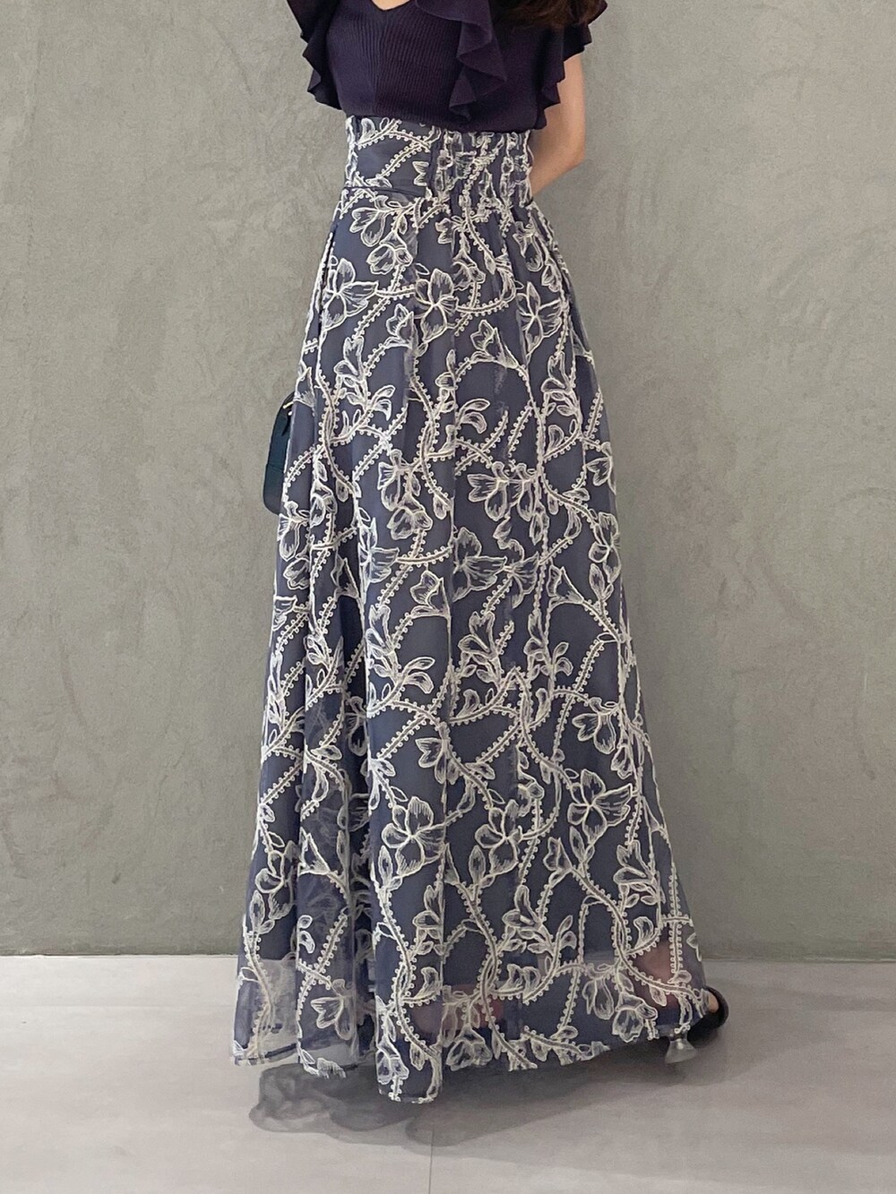 グレー系のスカート、グレー系のニット/セーター、ブラック系のサンダルを着用したレディースの夏コーディネートの5枚目の写真