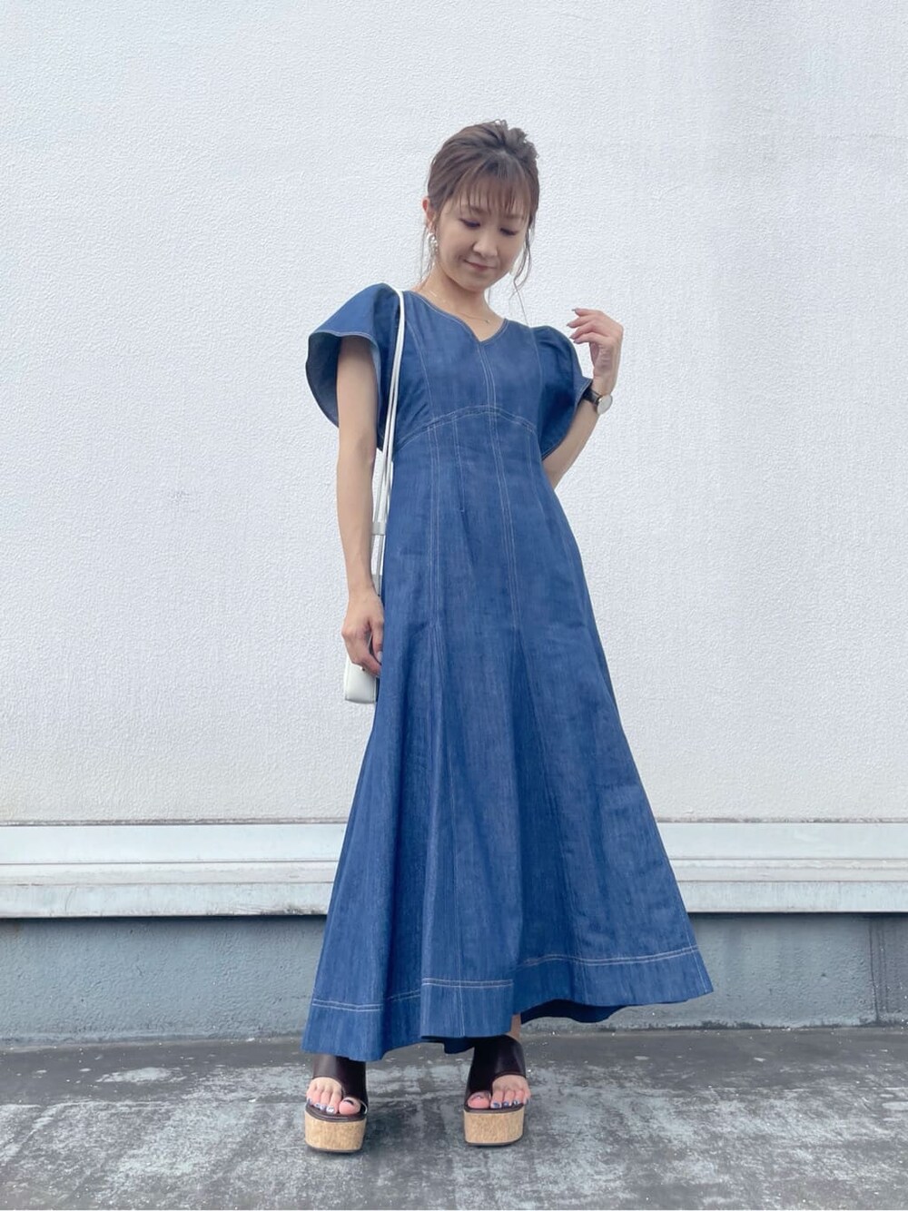 ブルー系のワンピース、ブラウン系のサンダル、ホワイト系のハンドバッグを着用したレディースの夏コーディネートの8枚目の写真