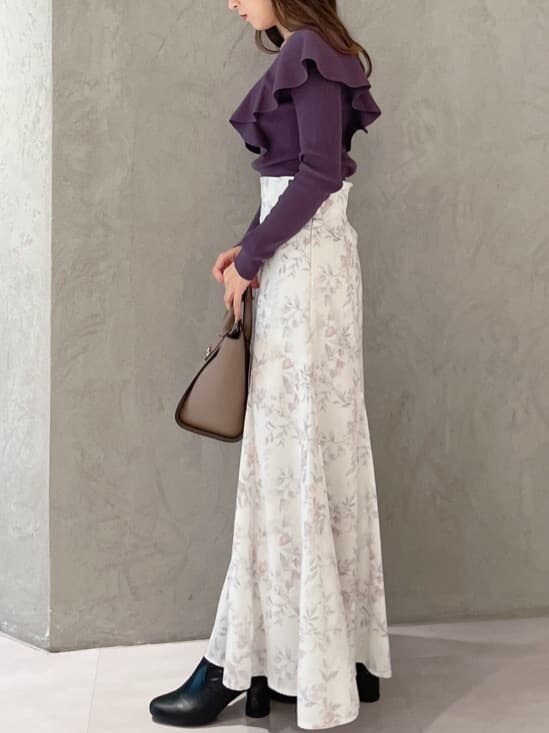 ピンク系のスカート、ブラウン系のハンドバッグ、パープル系のニット/セーターを着用したレディースの秋コーディネートの5枚目の写真