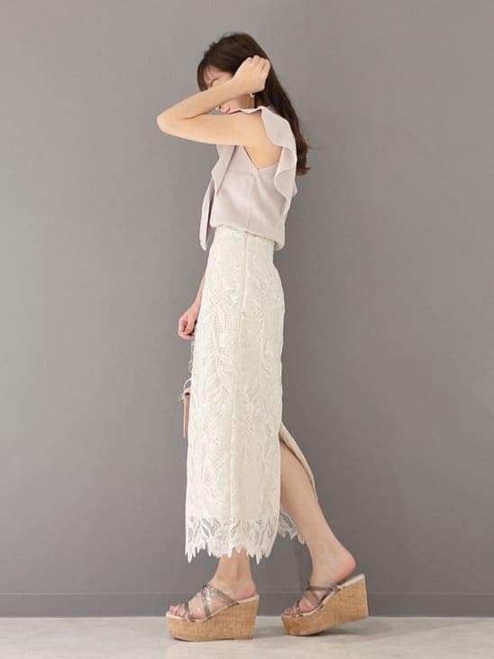 ホワイト系のスカート、ピンク系のショルダーバッグ、グリーン系のサンダルを着用したレディースの春コーディネートの3枚目の写真