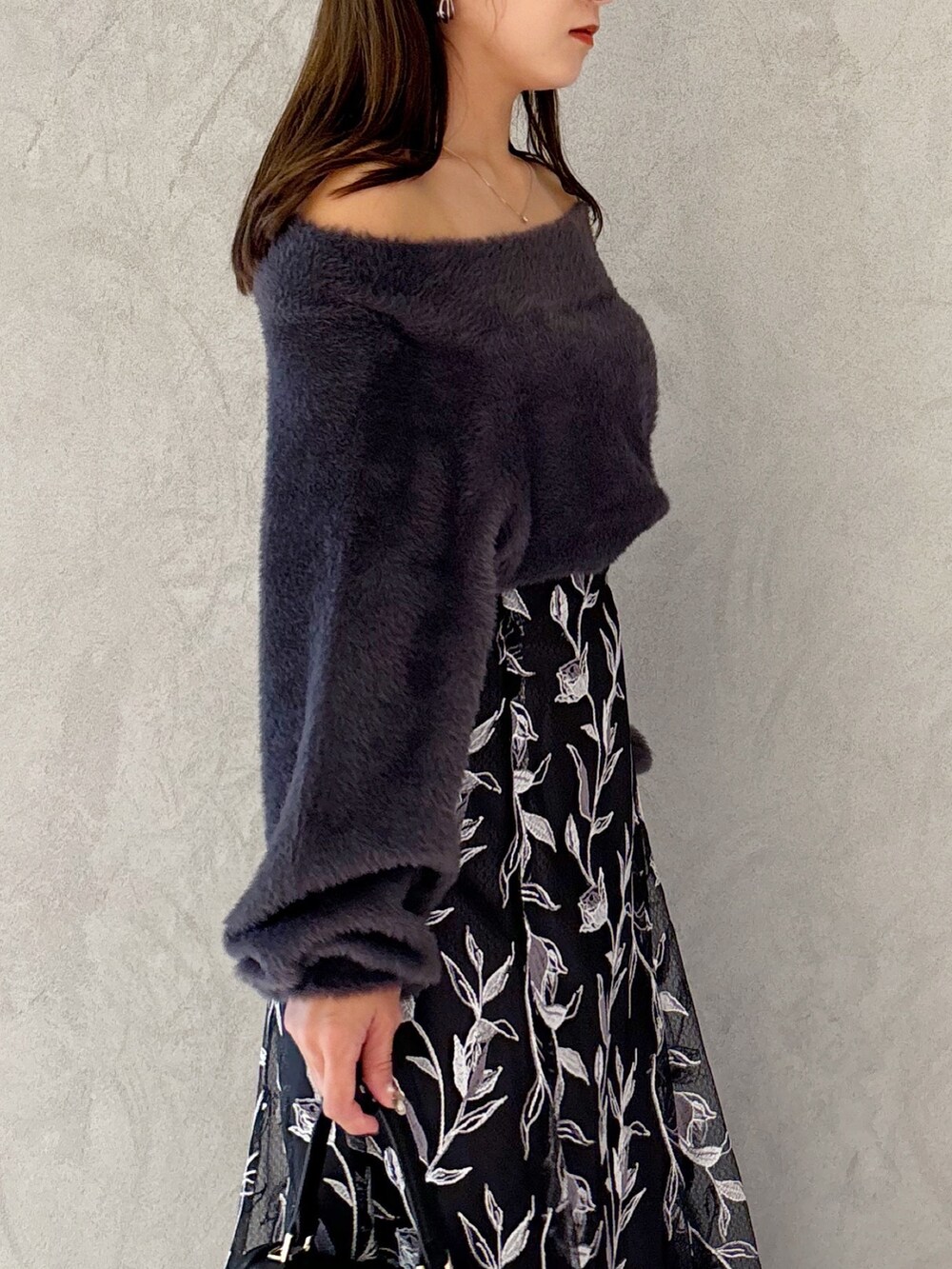 グレー系のスカート、ブラック系のブーツ、ブラック系のショルダーバッグを着用したレディースの秋コーディネートの3枚目の写真