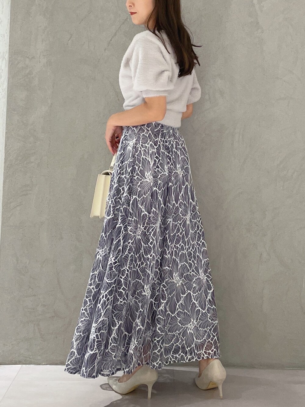 グレー系のカーディガン/ボレロ、ホワイト系のハンドバッグ、ホワイト系のパンプスを着用したレディースの夏コーディネートの2枚目の写真