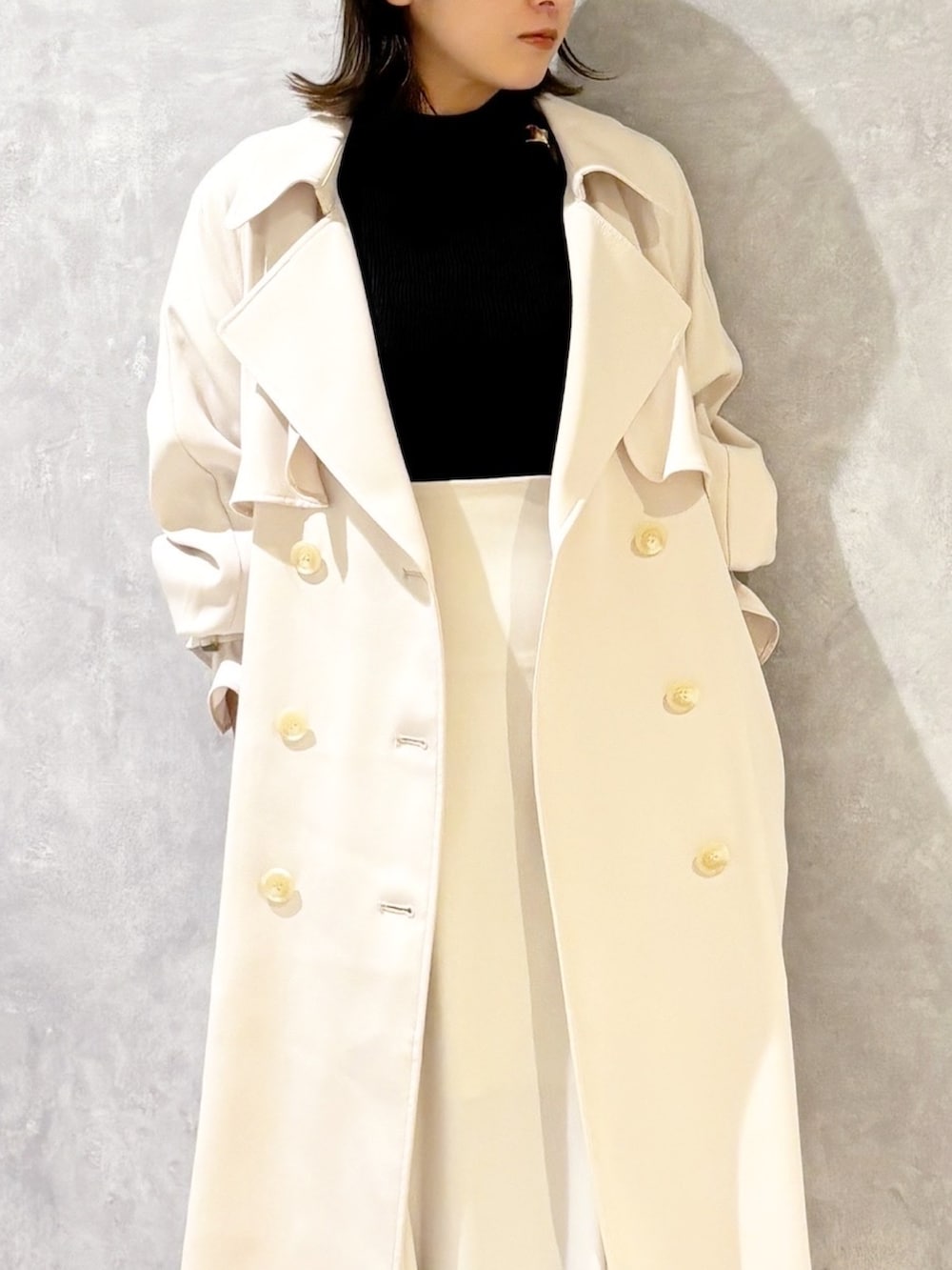 ホワイト系のスカート、ブラウン系のパンプス、ブラック系のニット/セーターを着用したレディースの春コーディネートの5枚目の写真