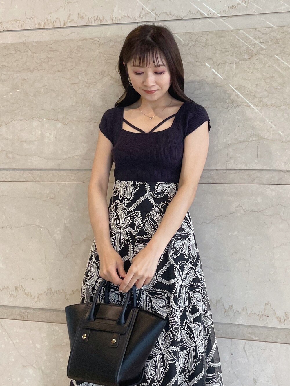 ブラック系のスカート、ブラック系のサンダル、ブラック系のトートバッグを着用したレディースの夏コーディネートの2枚目の写真