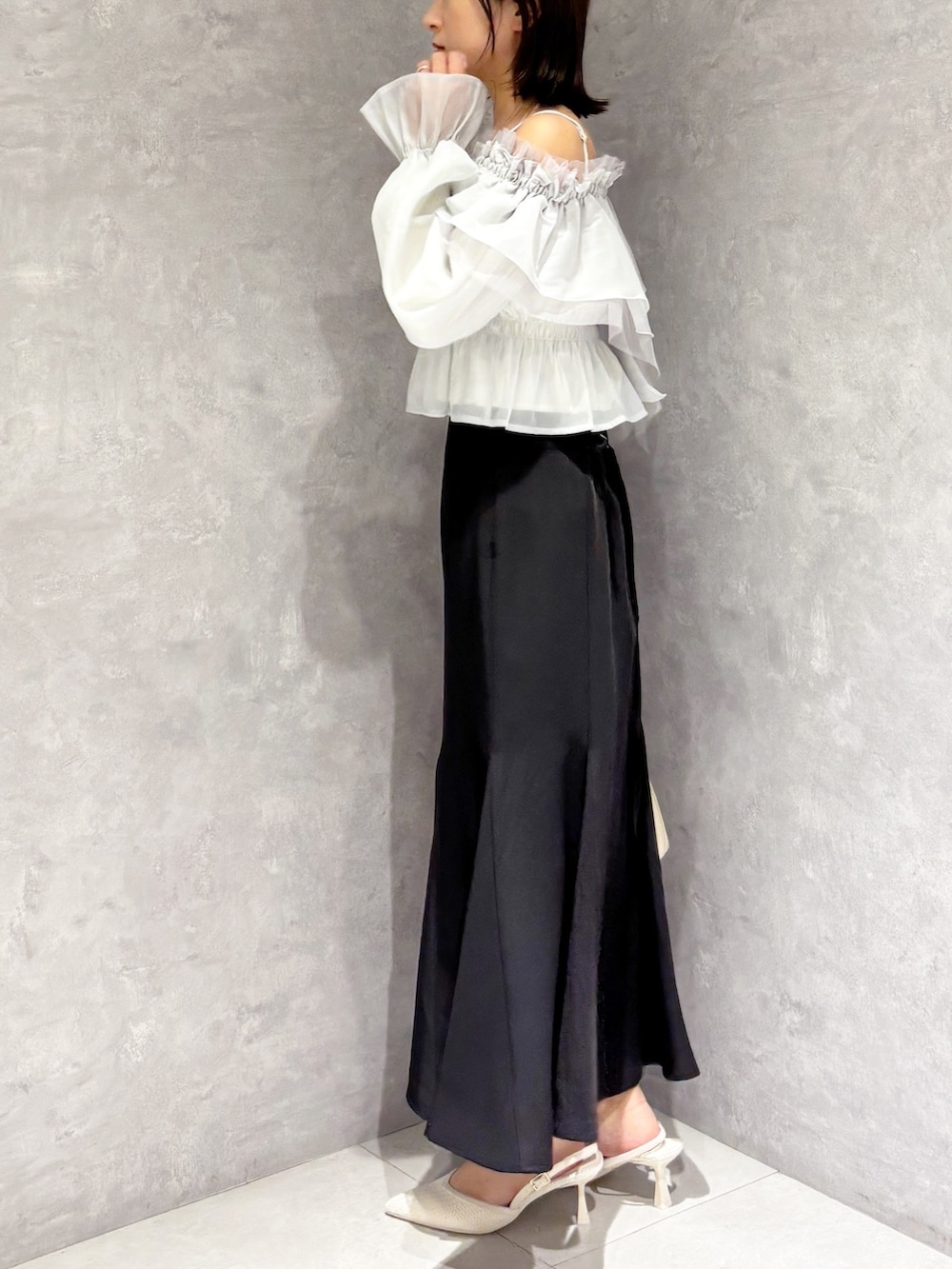 ブラック系のスカート、ホワイト系のパンプス、グリーン系のシャツ/ブラウスを着用したレディースの春コーディネートの4枚目の写真