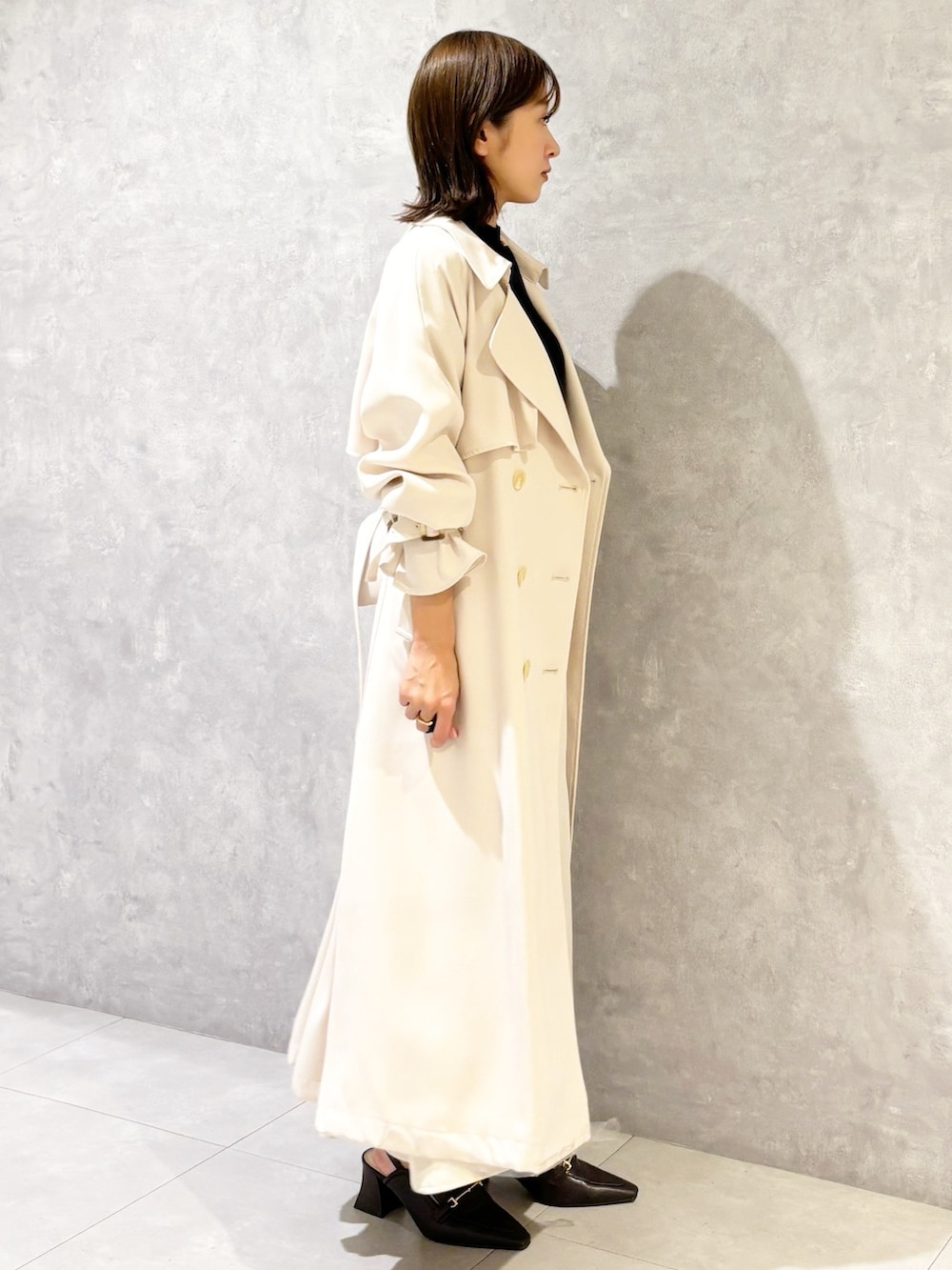 ホワイト系のスカート、ブラウン系のパンプス、ブラック系のニット/セーターを着用したレディースの春コーディネートの4枚目の写真