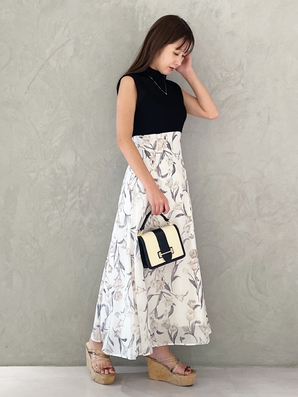 ブラック系のワンピース、ブラウン系のサンダル、ブラック系のハンドバッグを着用したレディースの夏コーディネートの2枚目の写真