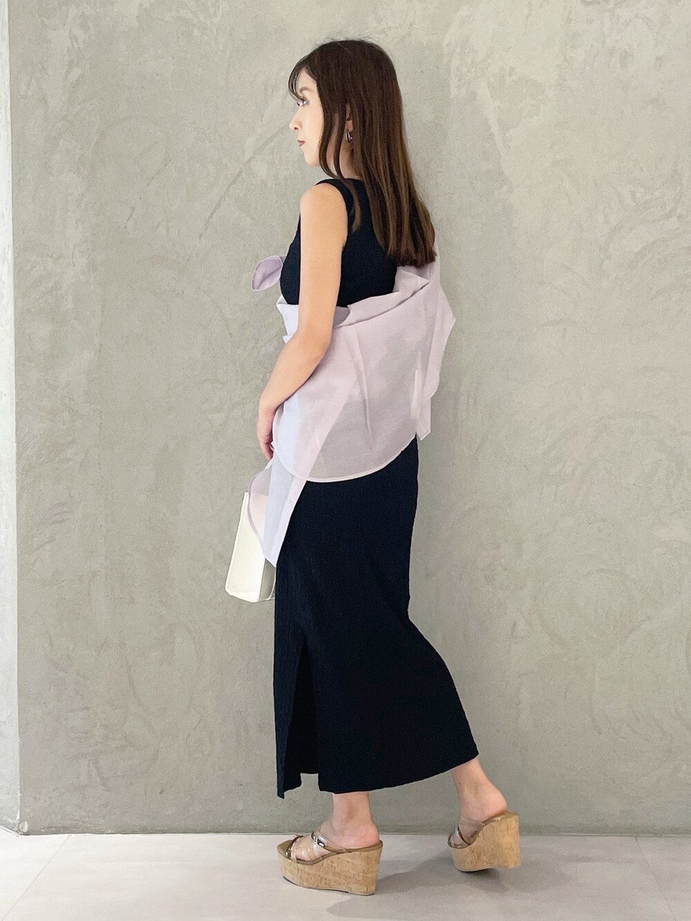 ピンク系のトートバッグ、ブラウン系のサンダル、ブラック系のワンピースを着用したレディースの夏コーディネートの3枚目の写真