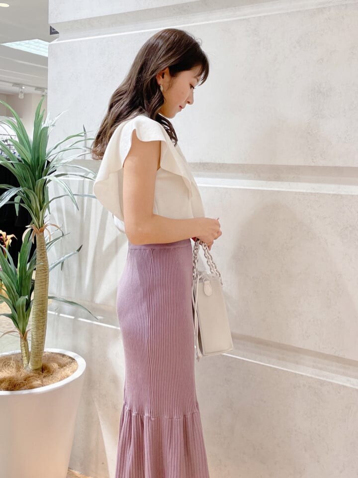 ホワイト系のハンドバッグ、ホワイト系のニット/セーター、グリーン系のサンダルを着用したレディースの春コーディネートの3枚目の写真