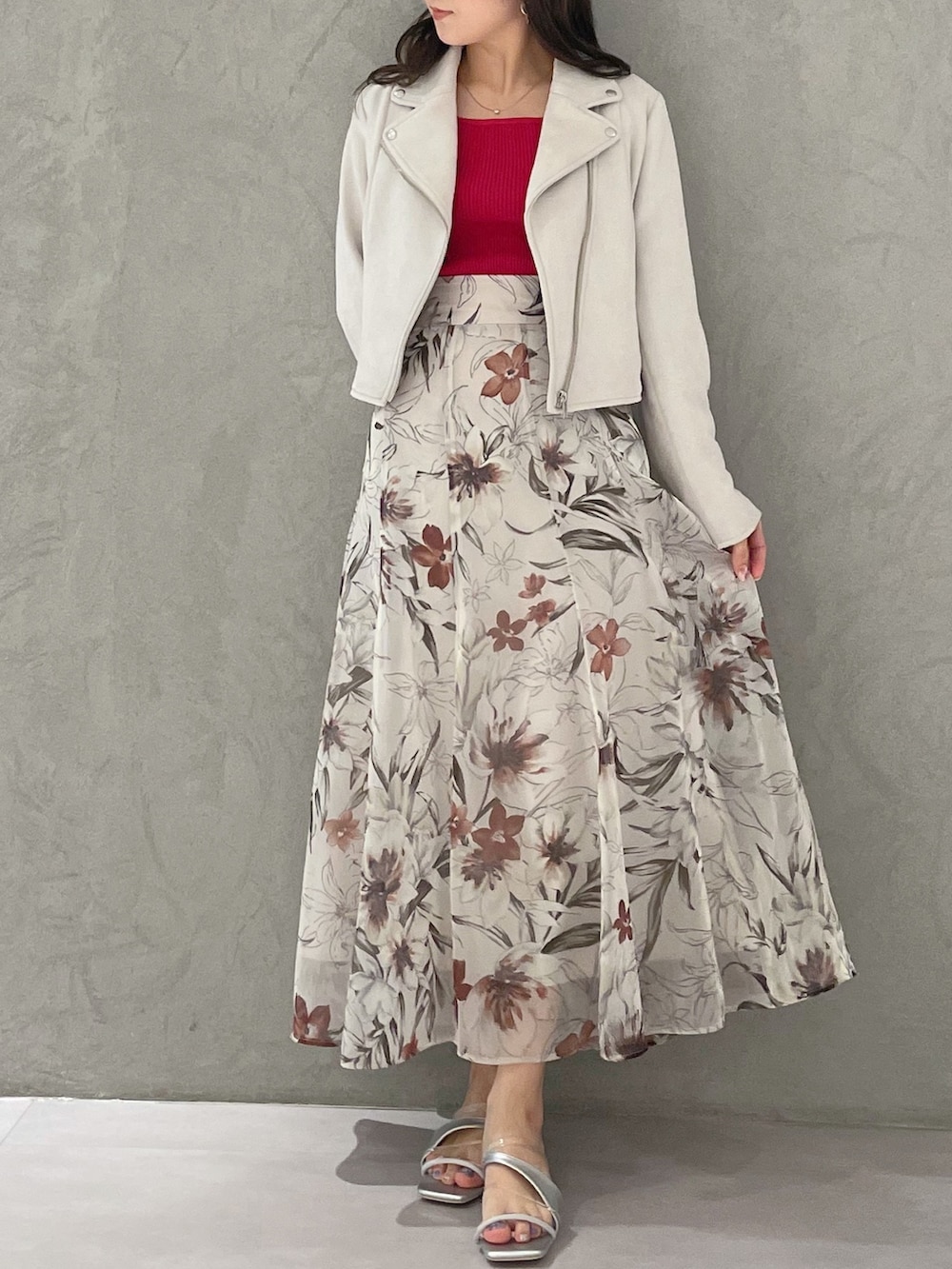 ピンク系のスカート、ピンク系のライダースジャケット、レッド系のニット/セーターを着用したレディースの春コーディネートの4枚目の写真