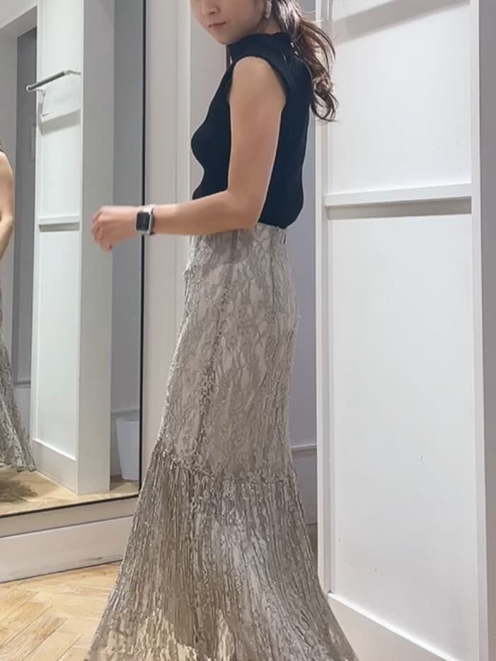 ブラック系のニット/セーター、ブラウン系のサンダル、グリーン系のスカートを着用したレディースの夏コーディネートの3枚目の写真