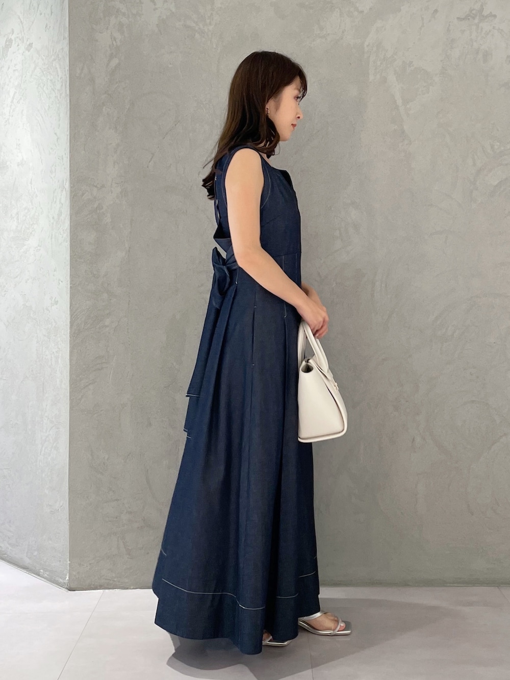 ブルー系のワンピース、シルバー系のサンダル、ホワイト系のトートバッグを着用したレディースの夏コーディネートの4枚目の写真