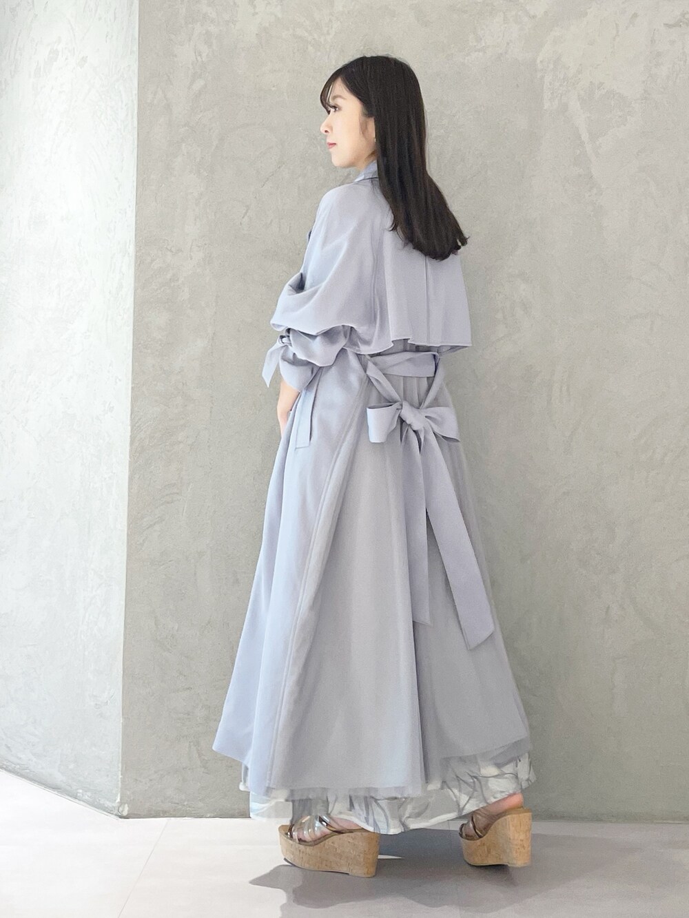 ブルー系のトレンチコート、ブラウン系のサンダル、ホワイト系のショルダーバッグを着用したレディースの春コーディネートの6枚目の写真