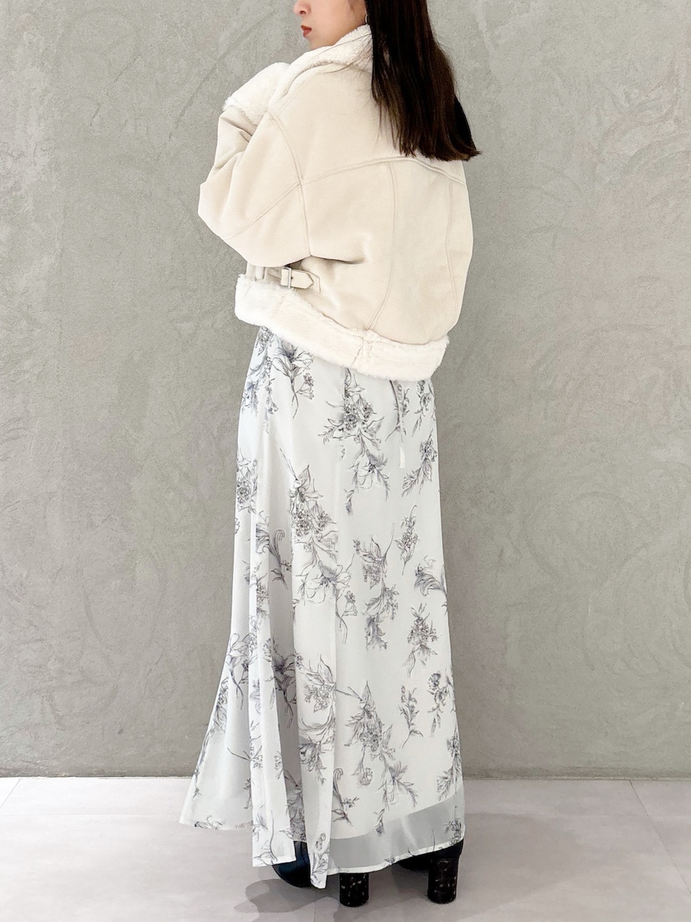 ブラック系のワンピース、ブラック系のブーツ、ホワイト系のハンドバッグを着用したレディースの秋コーディネートの7枚目の写真