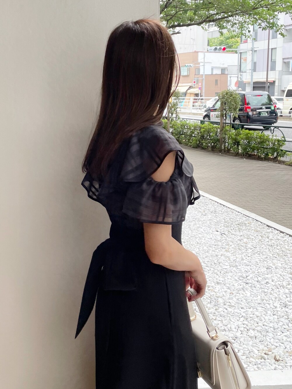 ブラック系のワンピース、ブラック系のサンダル、ホワイト系のショルダーバッグを着用したレディースの夏コーディネートの5枚目の写真