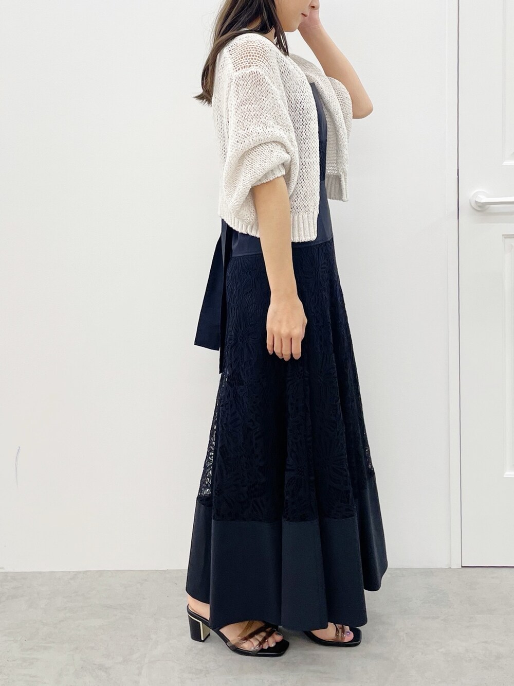 ブラック系のサンダル、ブラック系のワンピース、ベージュ系のカーディガン/ボレロを着用したレディースの春コーディネートの2枚目の写真