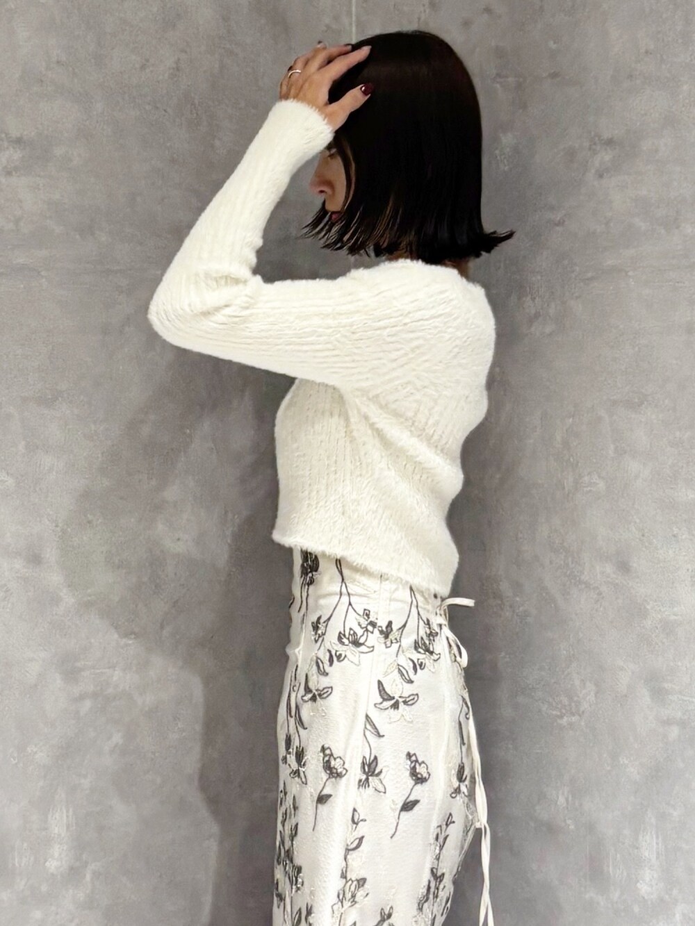 ホワイト系のスカート、ブラウン系のブーツ、ホワイト系のニット/セーターを着用したレディースの秋コーディネートの4枚目の写真