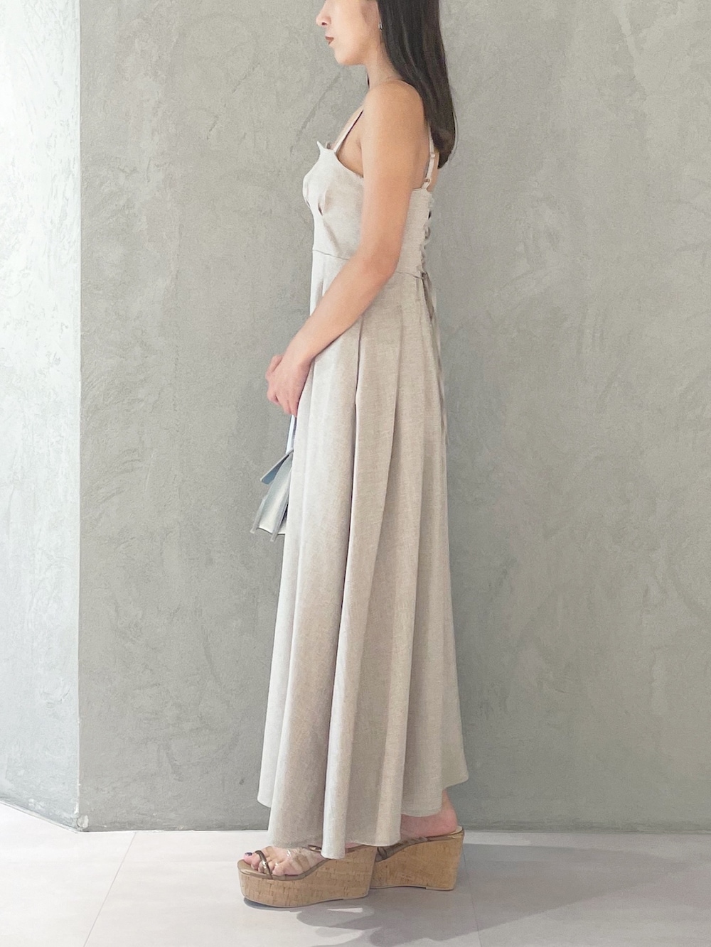 ベージュ系のワンピース、シルバー系のショルダーバッグ、ブラウン系のサンダルを着用したレディースの夏コーディネートの2枚目の写真