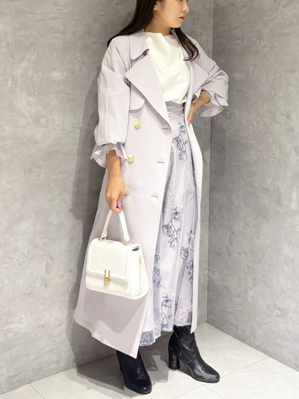 パープル系のスカート、ブラック系のブーツ、ホワイト系のハンドバッグを着用したレディースの冬コーディネートの4枚目の写真