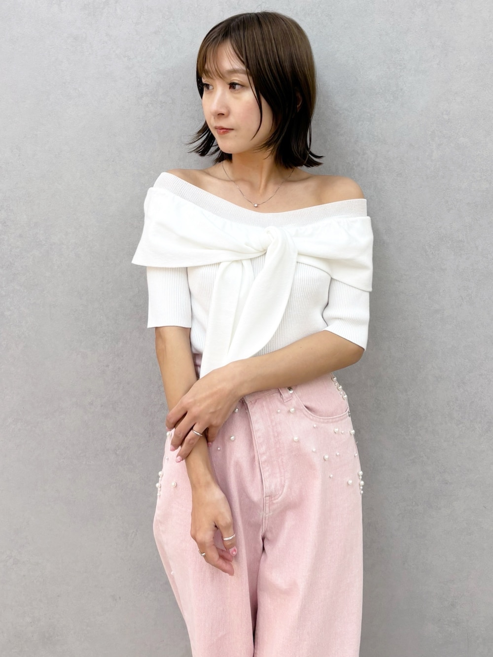 ピンク系のデニムパンツ、その他のサンダル、ホワイト系のニット/セーターを着用したレディースの春コーディネートの3枚目の写真