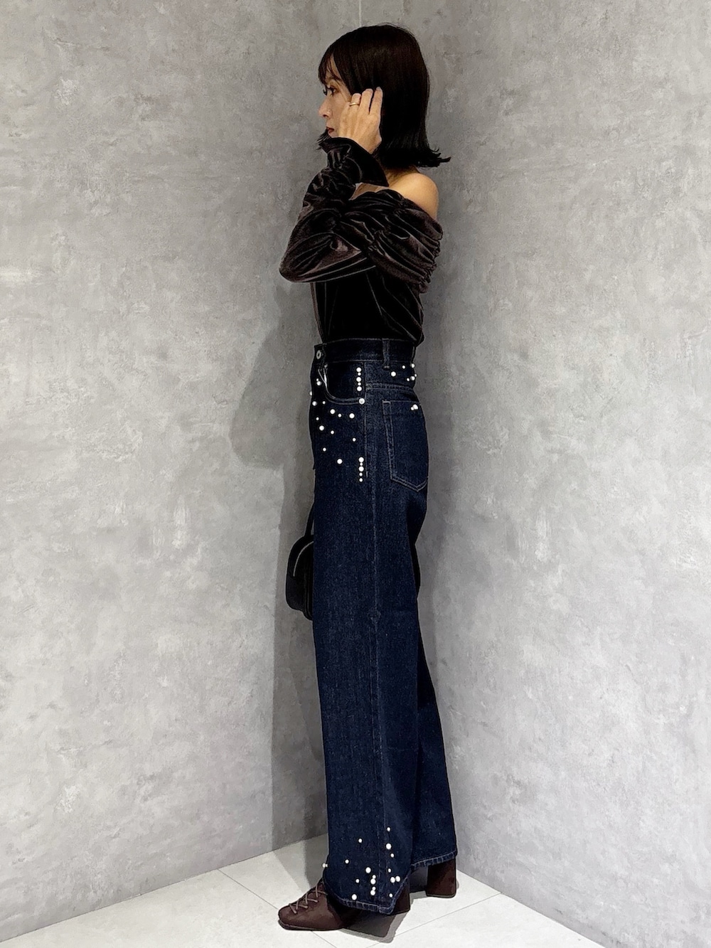 ブルー系のデニムパンツ、ブラウン系のTシャツ/カットソー、ブラウン系のブーツを着用したレディースの秋コーディネートの2枚目の写真