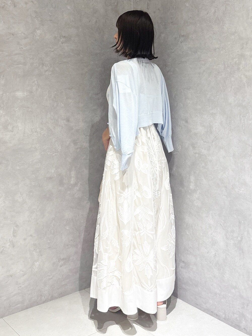 ホワイト系のワンピース、ホワイト系のサンダル、ホワイト系のハンドバッグを着用したレディースの夏コーディネートの5枚目の写真