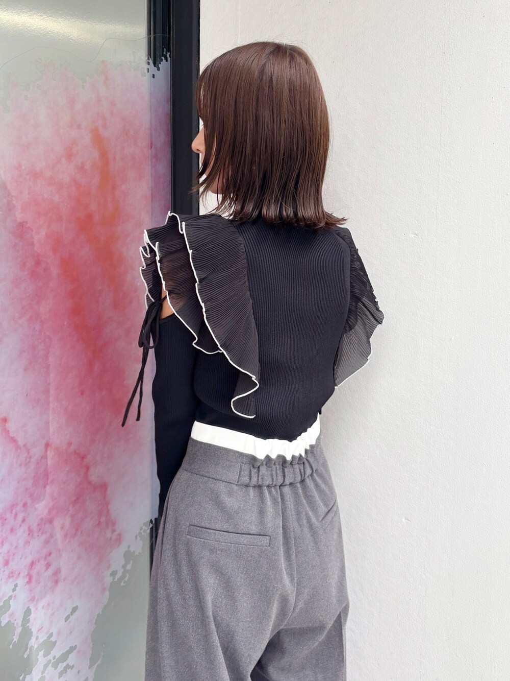 グレー系のその他パンツ、グレー系のパンプス、ブラック系のハンドバッグを着用したレディースの秋コーディネートの3枚目の写真