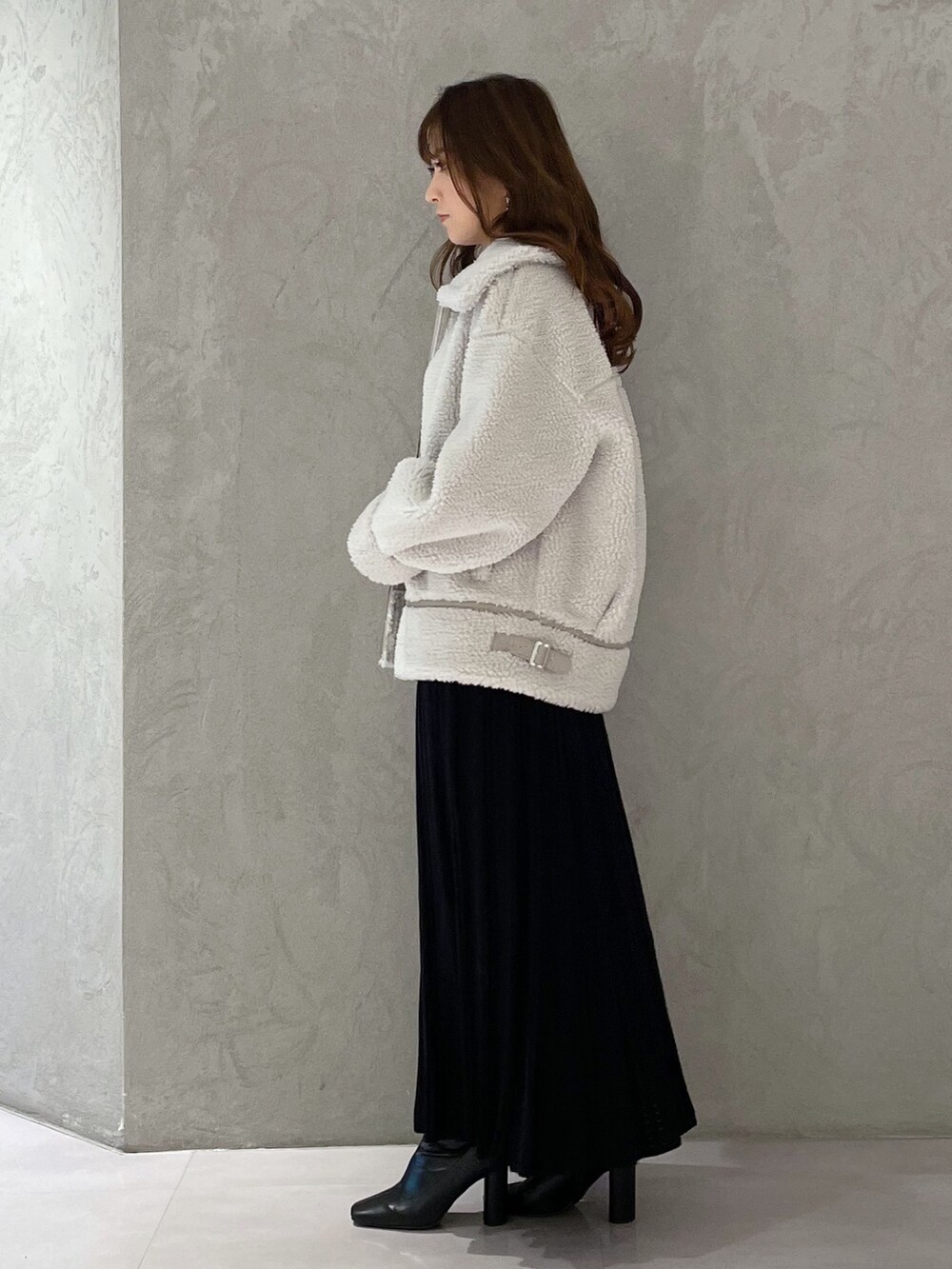 ブラック系のワンピース、ブラック系のブーツ、グレー系のその他アウターを着用したレディースの冬コーディネートの3枚目の写真