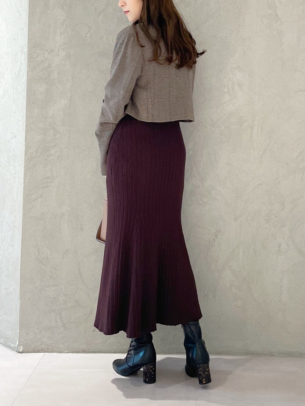 ブラウン系のワンピース、ブラック系のブーツ、ブラウン系のハンドバッグを着用したレディースの秋コーディネートの4枚目の写真