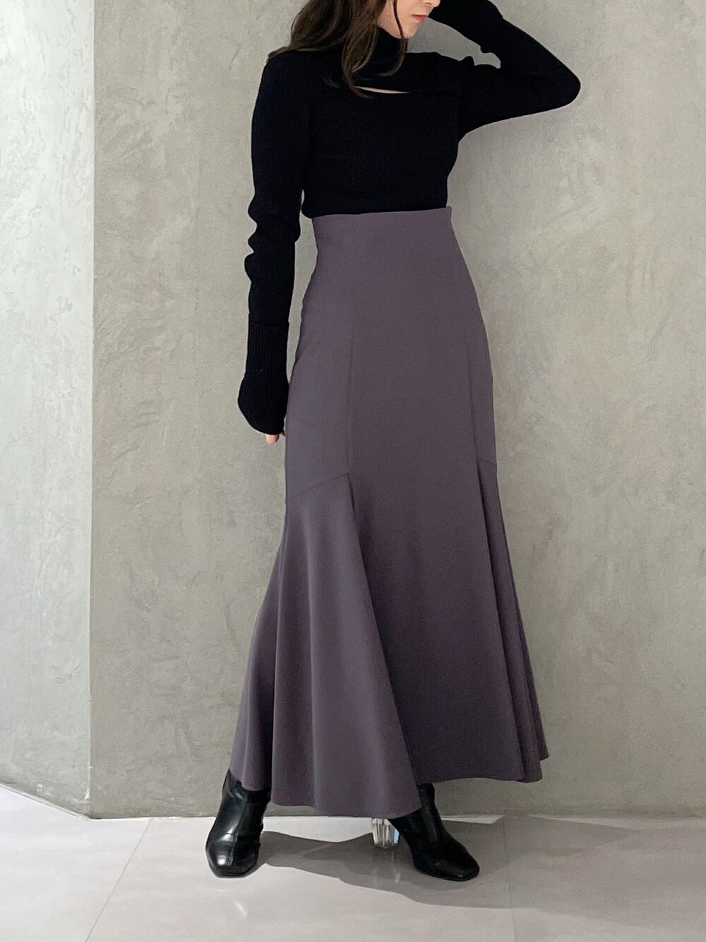 グレー系のスカート、グレー系のニット/セーター、ブラック系のブーツを着用したレディースの冬コーディネートの3枚目の写真