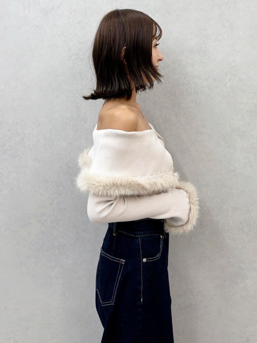 ブルー系のデニムパンツ、ブラウン系のブーツ、ベージュ系のニット/セーターを着用したレディースの秋コーディネートの6枚目の写真