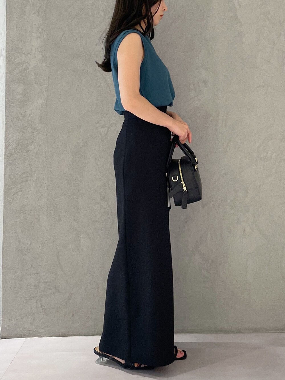 ブラック系のスカート、ブラック系のサンダル、ブラック系のボストンバッグを着用したレディースの春コーディネートの2枚目の写真