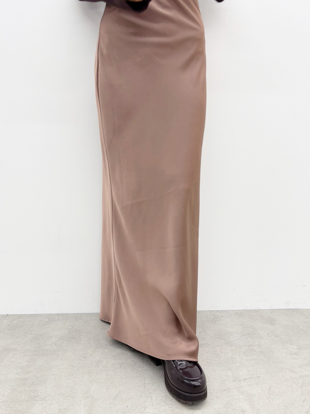 ブラウン系のスカート、ブラウン系のブーツ、ブラウン系のニット/セーターを着用したレディースの秋コーディネートの8枚目の写真