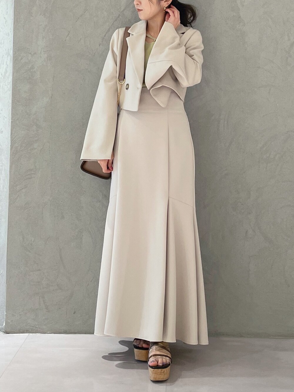 ブラック系のサンダル、ベージュ系のスカート、イエロー系のニット/セーターを着用したレディースの春コーディネートの7枚目の写真