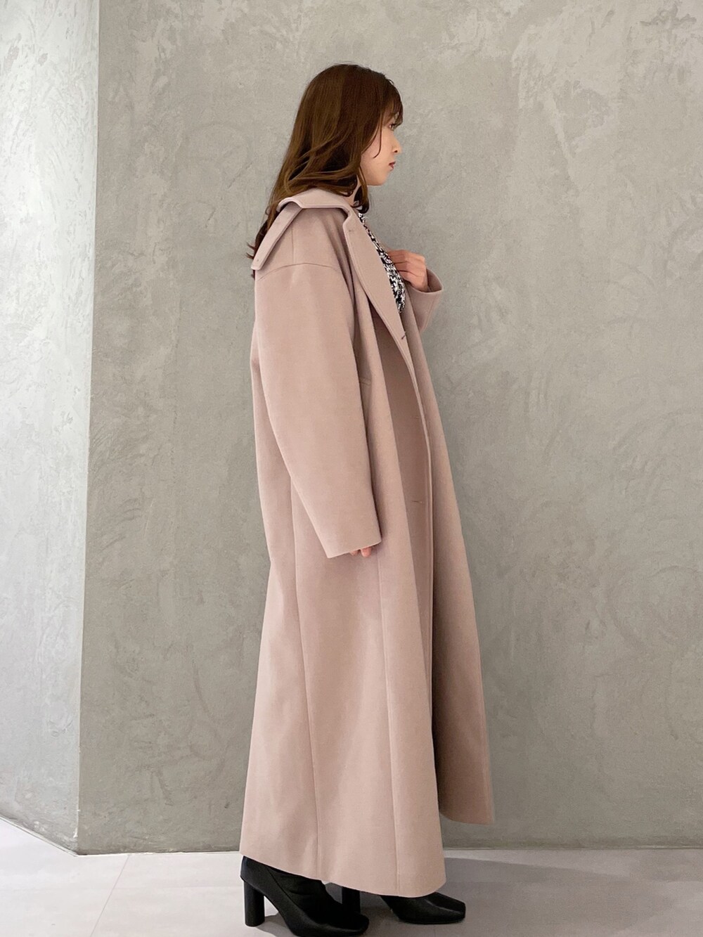 ブラック系のワンピース、ベージュ系のステンカラーコート、ブラック系のブーツを着用したレディースの秋コーディネートの2枚目の写真