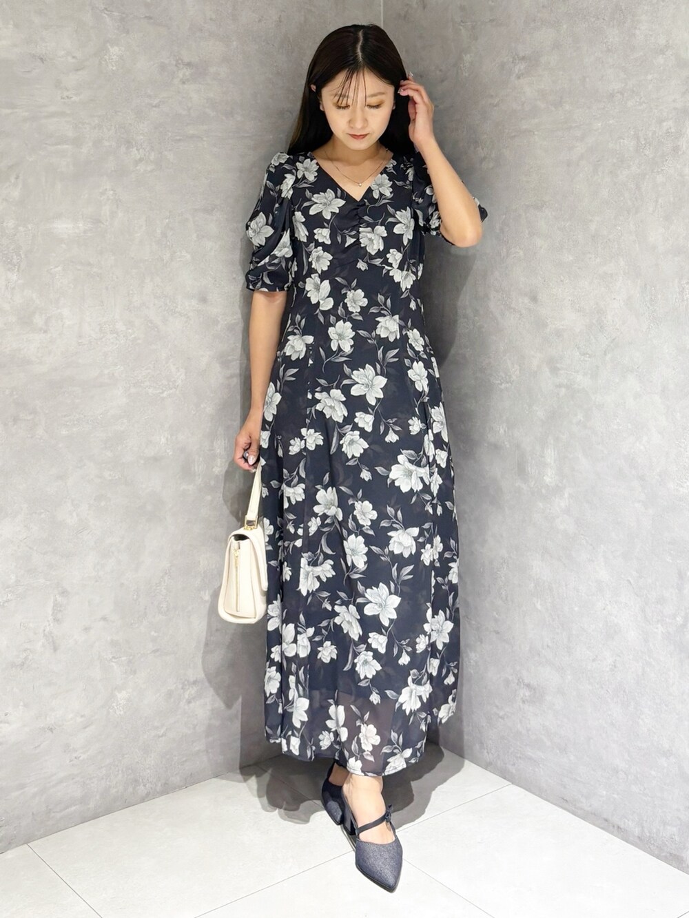 ブルー系のワンピース、ブルー系のパンプス、ホワイト系のハンドバッグを着用したレディースの春コーディネートの7枚目の写真