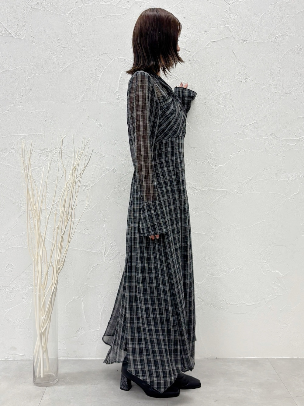 ブラック系のワンピース、ブラック系のブーツを着用したレディースの秋コーディネートの2枚目の写真