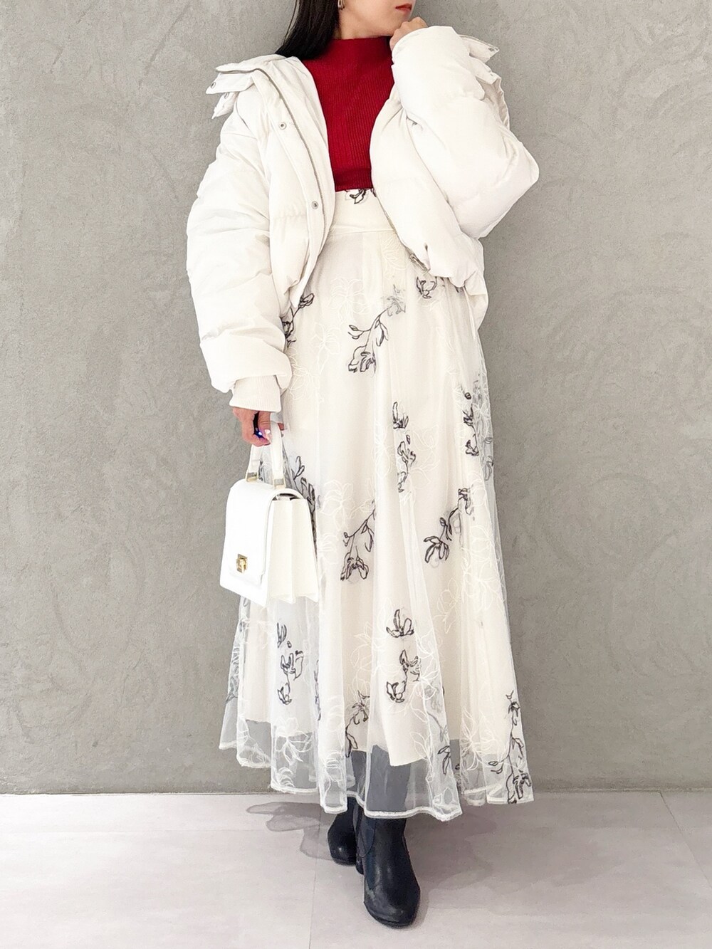 ホワイト系のスカート、ブラック系のブーツ、ホワイト系のハンドバッグを着用したレディースの冬コーディネートの7枚目の写真